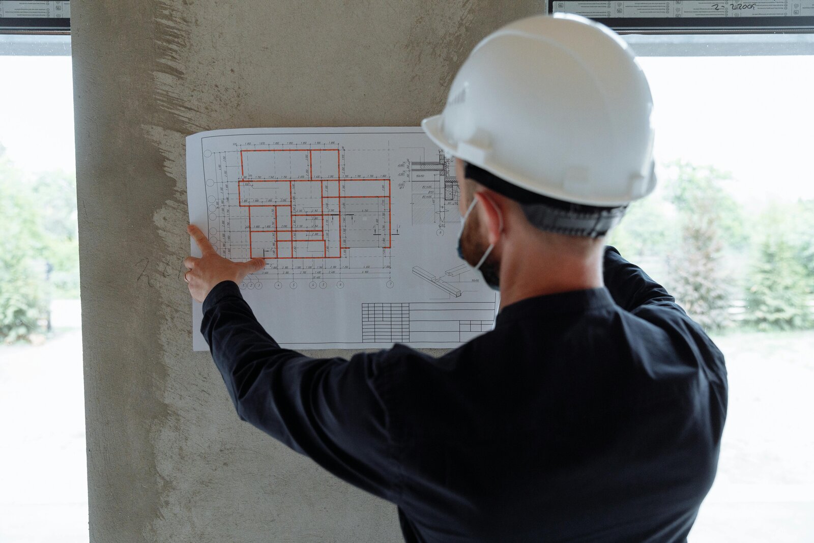 Site engineer reviewing drawings on wall